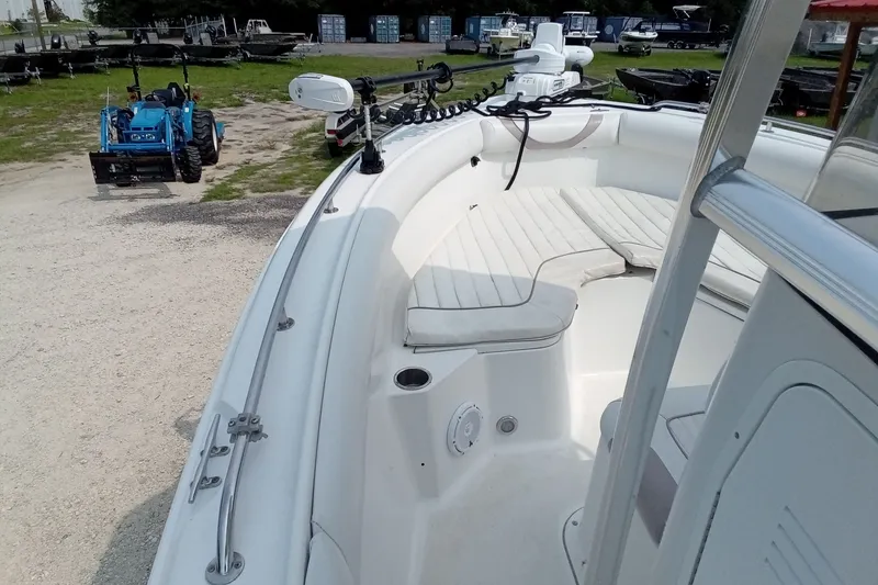 Slide: The Image of 2009 Sea Hunt Ultra 232 boat interior with seating and equipment, parked near a blue tractor. - 22