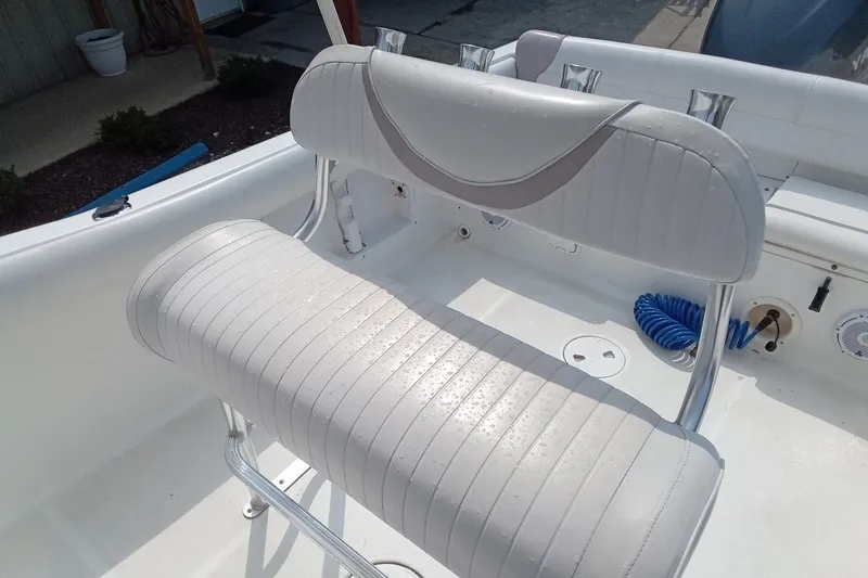 Slide: The Image of 2009 Sea Hunt Ultra 232 boat interior with white cushioned seating and rod holders. - 21