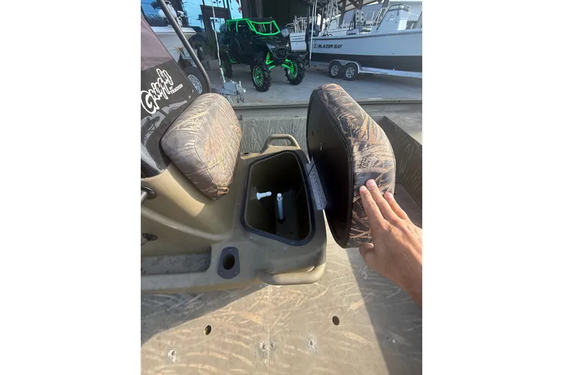 Slide: The Image of 2019 Tracker Grizzly 1860 boat seat storage compartment with camouflage cushion. - 14