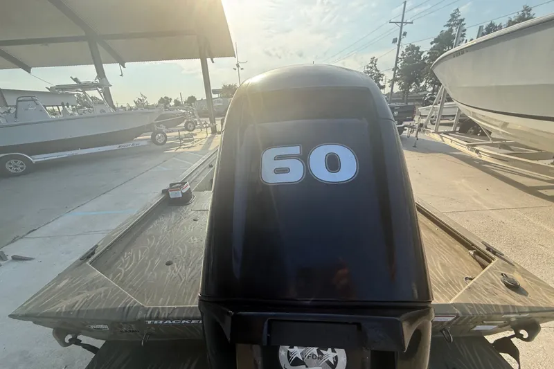 Slide: The Image of 2019 Tracker Grizzly 1860 boat with 60 HP engine in a sunny marina. - 4