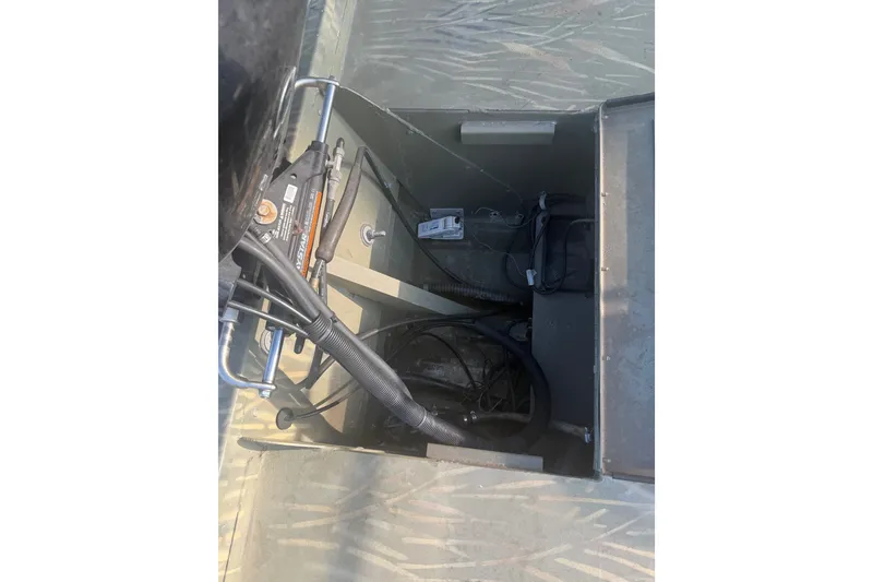 Slide: The Image of 2019 Tracker Grizzly 1860 boat interior showing wiring and mechanical components. - 12