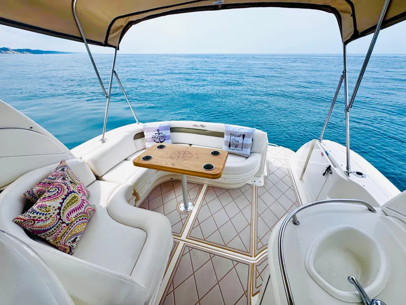 Slide: The Image of The image shows the aft of a 2006 Sea Ray 340 Sundancer with beige upholstery and a wooden table. - 8