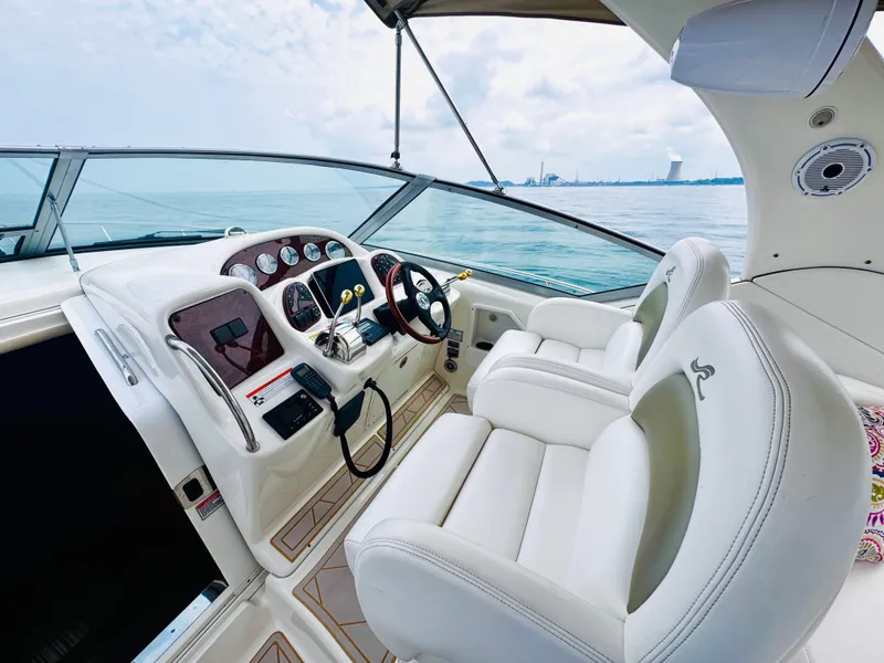 Slide: The Image of The image shows the cockpit of a 2006 Sea Ray 340 Sundancer with two white seats and a modern dashboard. - 19