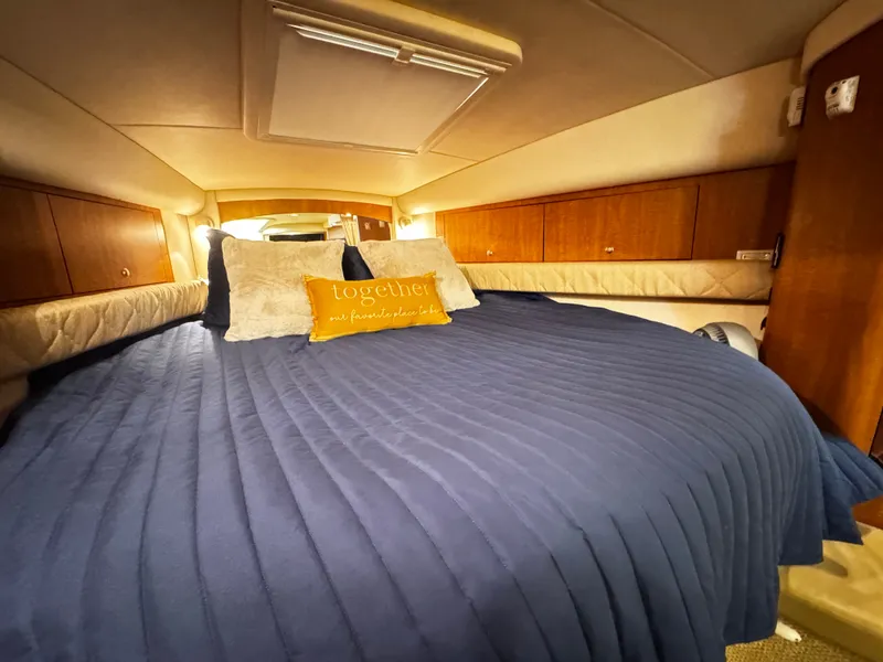 Slide: The Image of The 2006 Sea Ray 340 Sundancer cabin features a cozy bed with a blue cover. - 32