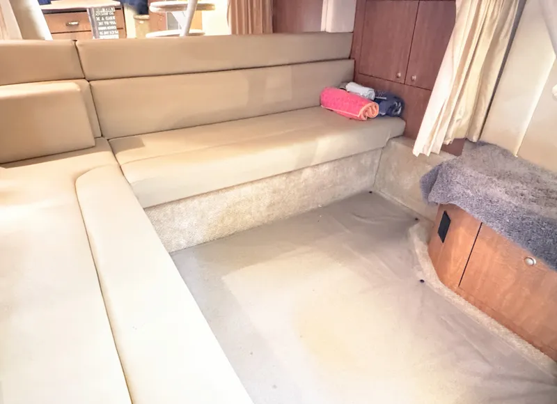 Slide: The Image of Interior of the 2006 Sea Ray 340 Sundancer with beige upholstered seating and wooden cabinetry. - 34