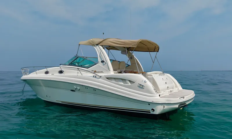 Slide: The Image of A 2006 Sea Ray 340 Sundancer on calm water with a beige canopy and spacious deck. - 6