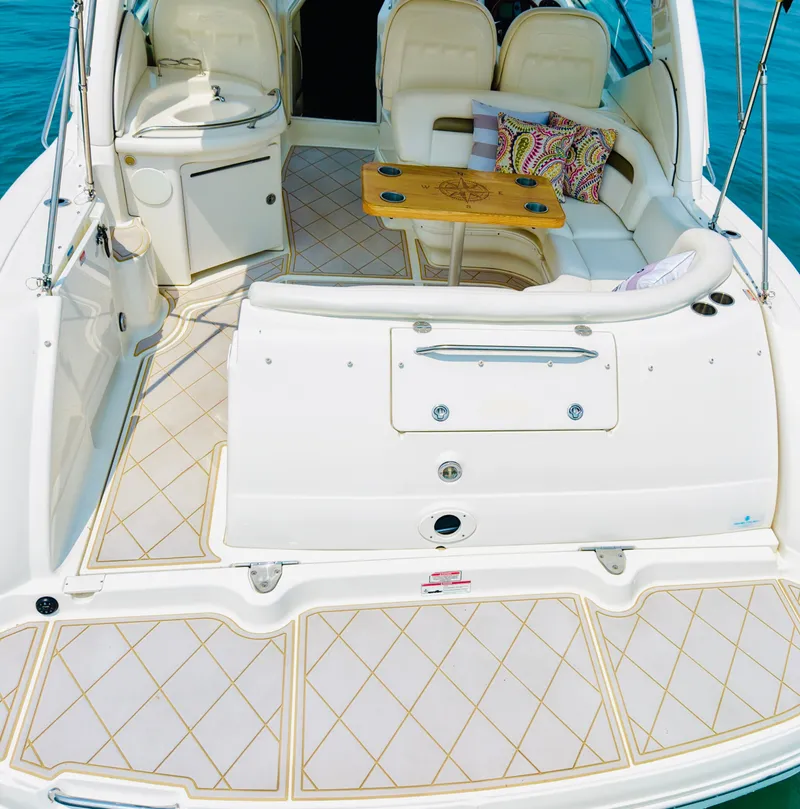 Slide: The Image of The image shows the cockpit of a 2006 Sea Ray 340 Sundancer with beige upholstery and a wooden table. - 9