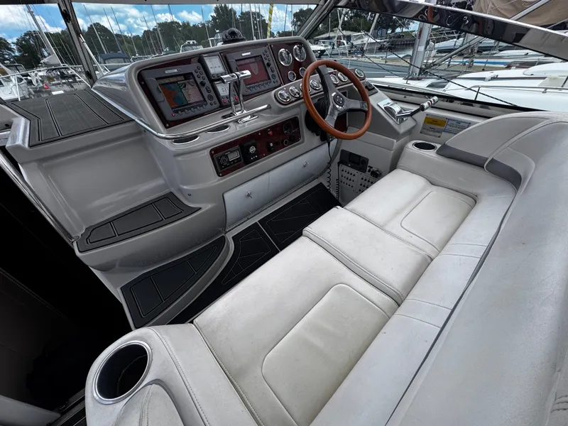 Slide: The Image of The cockpit of a 2004 Formula 40 Performance Cruiser with white cushioned seating and a wooden steering wheel. - 6