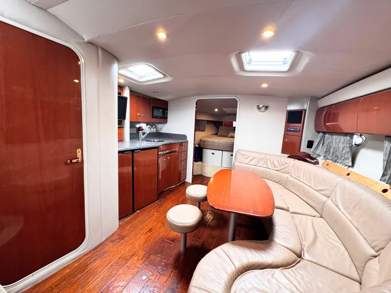Slide: The Image of The interior cabin of a 2004 Formula 40 Performance Cruiser with elegant wood flooring, a kitchenette, and seating area. - 17