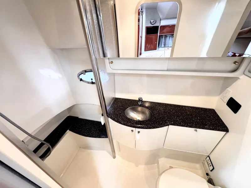 Slide: The Image of The image shows the bathroom of a 2004 Formula 40 Performance Cruiser. It features a shower, sink, and toilet. - 15