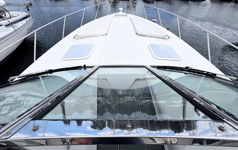 Slide: The Image of The front view of a white boat with a glass roof and two hatches, docked on water. - 3