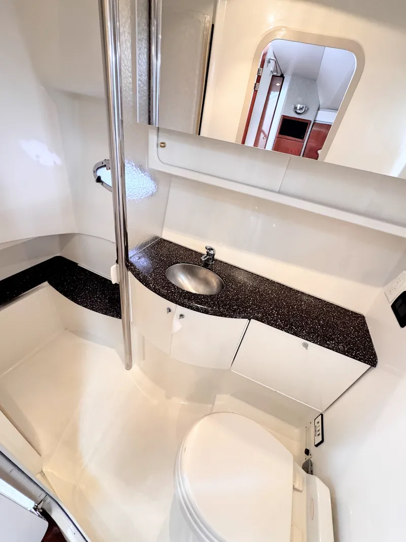 Slide: The Image of The image shows the bathroom of a 2004 Formula 40 Performance Cruiser with a sink, toilet, and mirror. - 14
