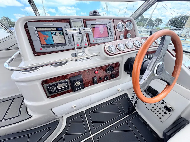 Slide: The Image of The cockpit of a 2004 Formula 40 Performance Cruiser with a wooden steering wheel and modern navigation systems. - 8