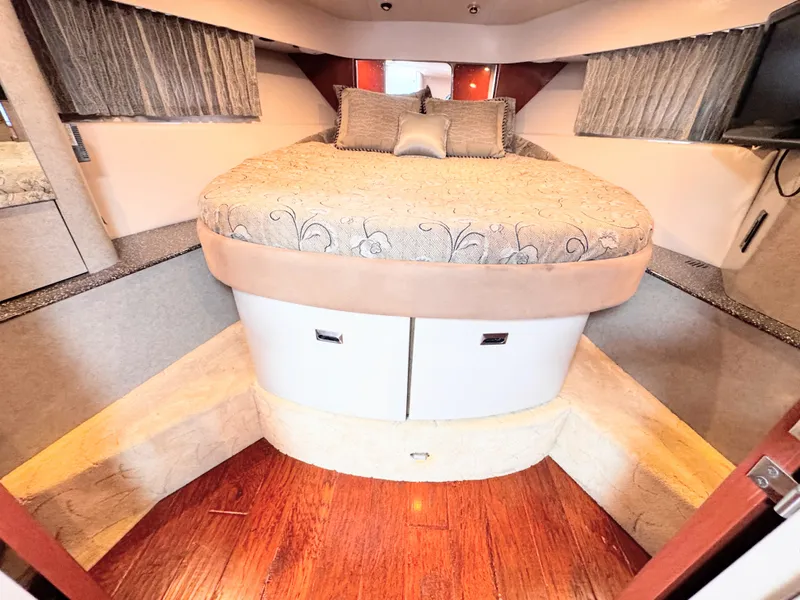Slide: The Image of The cabin of a 2004 Formula 40 Performance Cruiser features a cozy bed with pillows and curtains. - 19