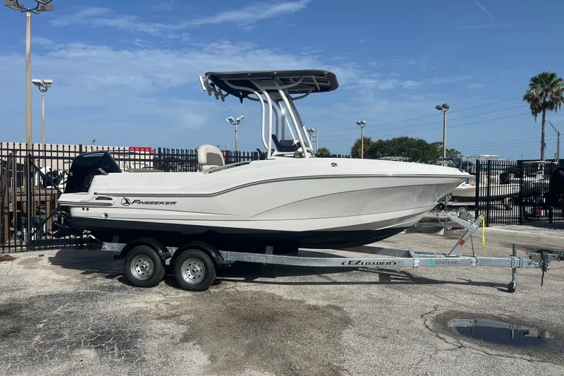 The Image of 2023 Crownline 220 CC Finseeker boat on trailer, parked outdoors. - 0