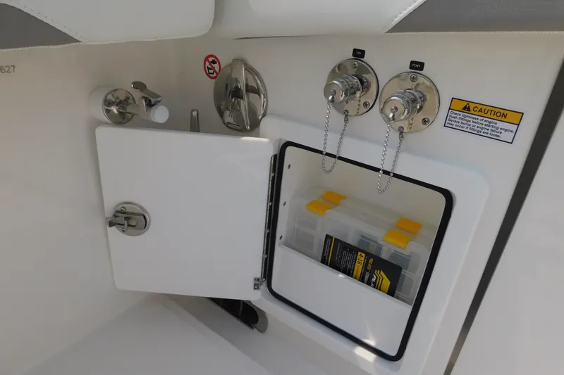Slide: The Image of 2026 Regulator 31 boat storage compartment with caution label and utility access. - 17
