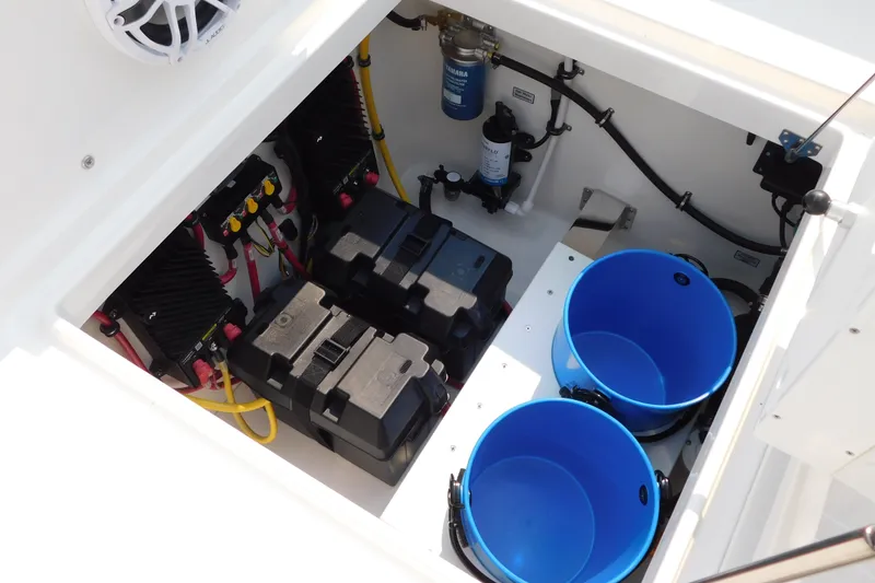 Slide: The Image of 2026 Regulator 31 boat compartment with batteries, wiring, and blue storage buckets. - 20