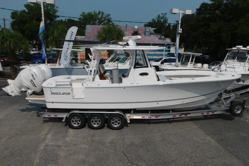 Slide: The Image of 2026 Regulator 31 boat on trailer, featuring twin Yamaha engines, displayed outdoors. - 1