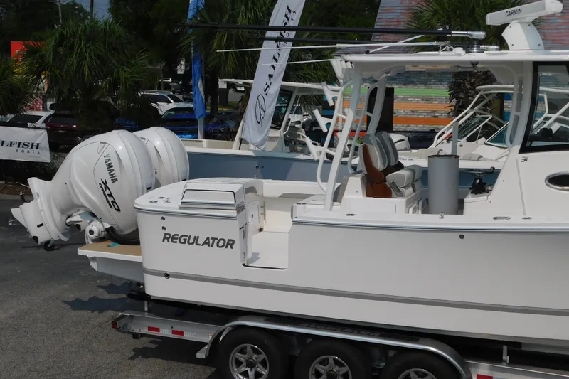 Slide: The Image of 2026 Regulator 31 boat with Yamaha engines on a trailer, displayed outdoors. - 6