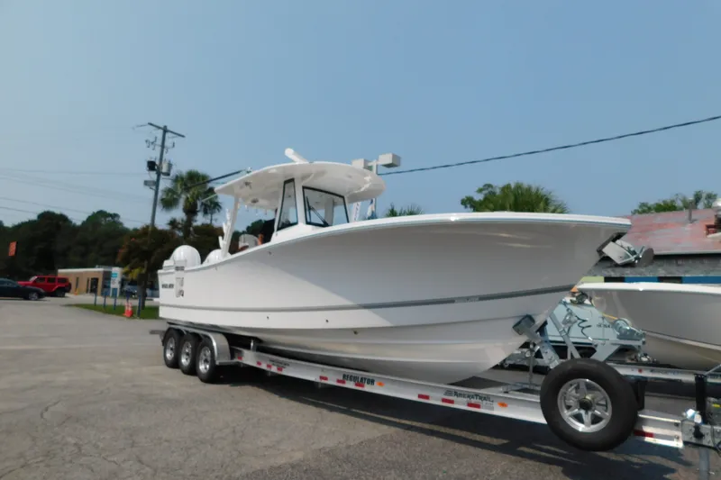 Slide: The Image of 2026 Regulator 31 boat on a trailer in a parking lot, ready for transport. - 2