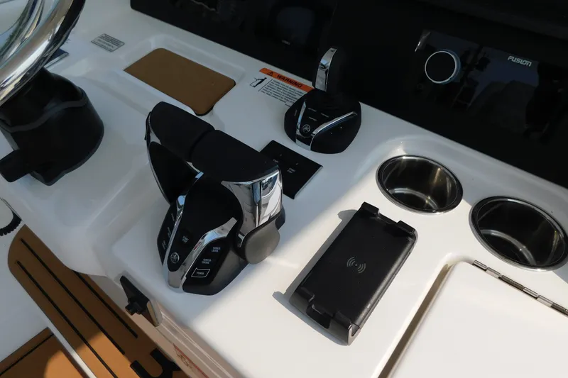 Slide: The Image of 2026 Regulator 31 boat console with controls, cup holders, and wireless charging pad. - 27