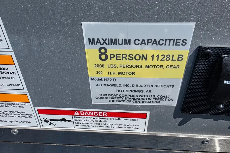 Slide: The Image of Capacity label on 2027 Xpress H20B Bay boat, 8-person, 1128 lbs limit. - 14