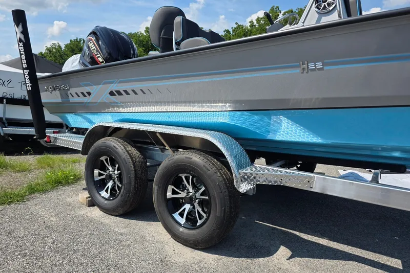 Slide: The Image of 2027 Xpress H20B Bay boat on trailer, featuring sleek design and dual wheels. - 2