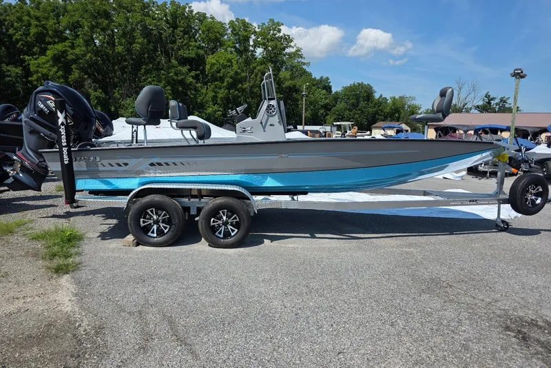 The Image of 2027 Xpress H20B Bay boat on trailer, parked outdoors under a clear sky. - 1