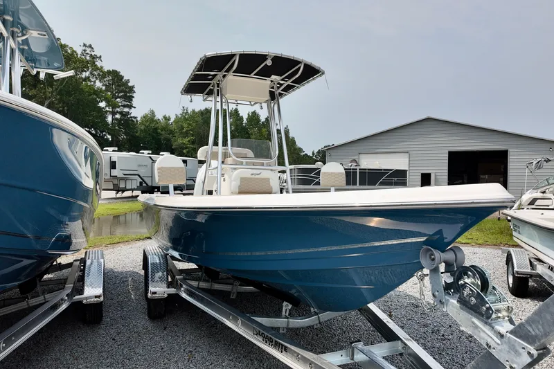 The Image of 2027 Bulls Bay 2200 XS boat on trailer, parked outdoors near a storage building. - 0