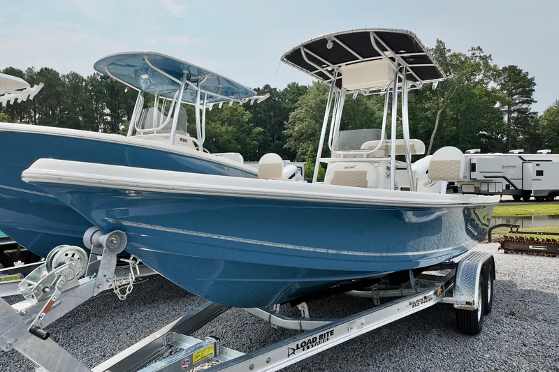 Slide: The Image of 2027 Bulls Bay 2200 XS boat on trailer, blue hull, parked outdoors. - 1