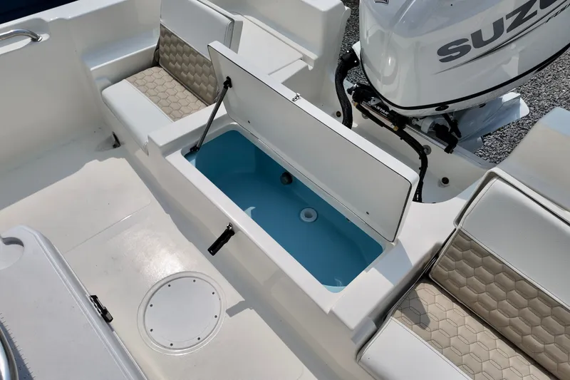 Slide: The Image of 2027 Bulls Bay 2200 XS boat interior with open storage compartment and Suzuki engine. - 5