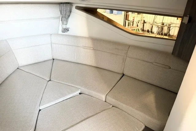 Slide: The Image of 2027 Sea Ray Sundancer 320 interior with plush beige seating and modern design. - 12