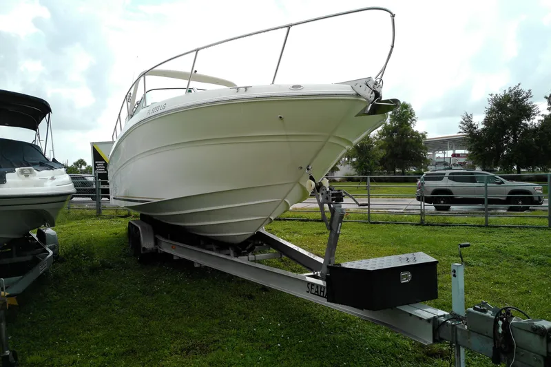 Slide: The Image of 1998 Sea Ray Sundancer 310 boat on trailer, parked on grass, overcast sky. - 4