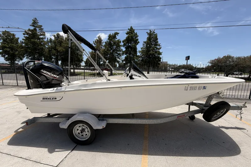 Slide: The Image of 2022 Boston Whaler 160 Super Sport boat on trailer, parked outdoors. - 4