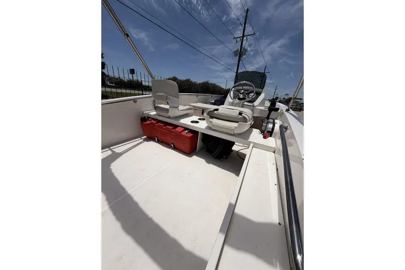 Slide: The Image of 2022 Boston Whaler 160 Super Sport interior with steering wheel and seating under a clear sky. - 6