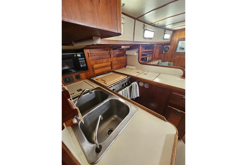 Slide: The Image of 1997 Valiant 42 yacht interior kitchen with wooden cabinetry and stainless steel sink. - 8