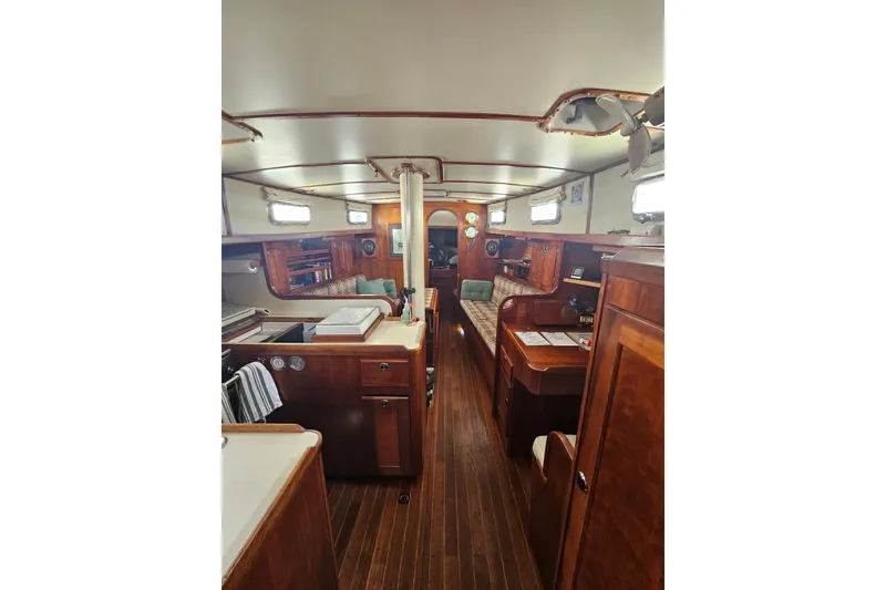 Slide: The Image of Interior of 1997 Valiant 42 sailboat with wooden furnishings and cozy seating area. - 6
