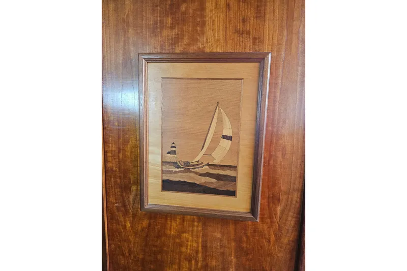 Slide: The Image of Framed wooden artwork of a sailboat and lighthouse on a Valiant 42, 1997 model. - 14