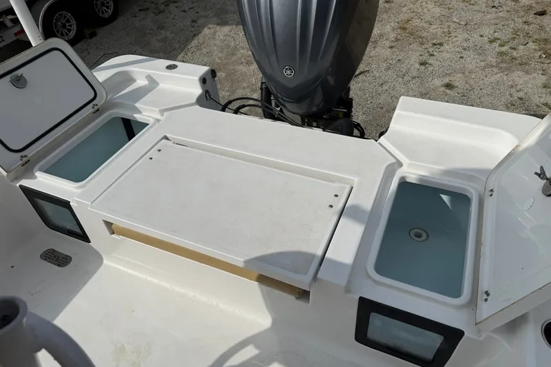 Slide: The Image of 2022 Sportsman Masters 247OE Bay Boat with open storage compartments and motor. - 6