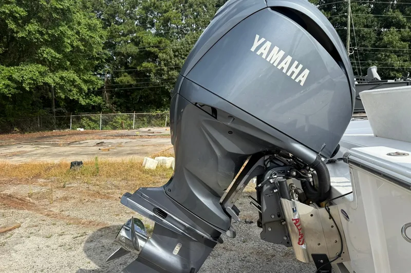 Slide: The Image of 2022 Sportsman Masters 247OE Bay Boat with Yamaha outboard motor in a wooded area. - 3
