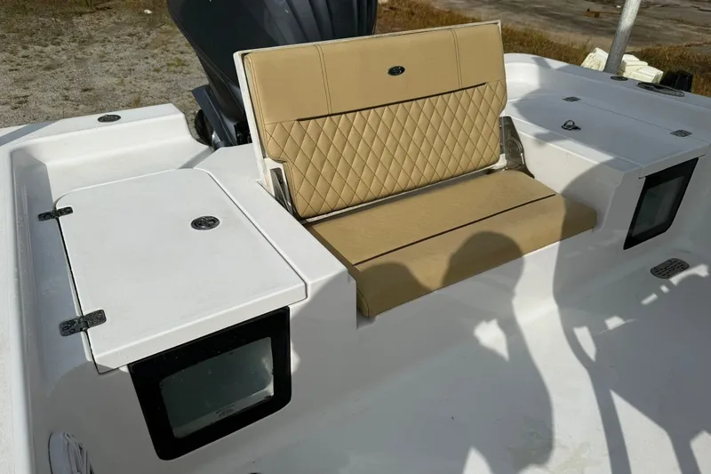 Slide: The Image of 2022 Sportsman Masters 247OE Bay Boat with tan cushioned seating and storage compartments. - 5