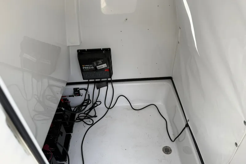 Slide: The Image of Battery compartment of 2022 Sportsman Masters 247OE Bay Boat with charger and cables. - 12