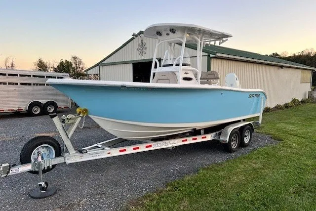The Image of 2021 Sea Pro 219 Center Console boat on trailer, parked near a barn. - 0