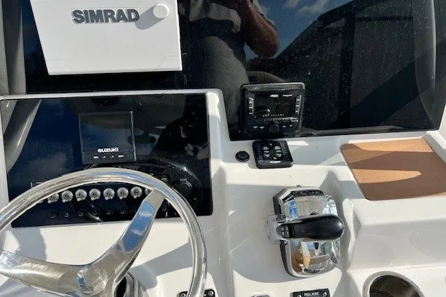 Slide: The Image of 2021 Sea Pro 219 Center Console dashboard with Simrad electronics and Suzuki controls. - 12