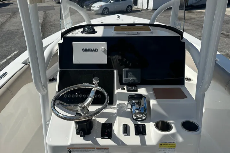 Slide: The Image of 2021 Sea Pro 219 Center Console boat dashboard with steering wheel and Simrad display. - 22