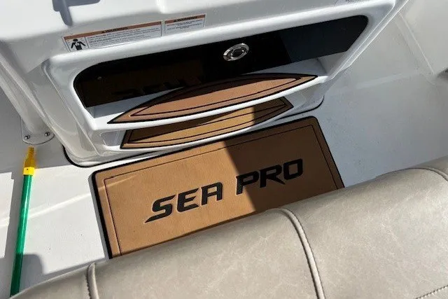 Slide: The Image of 2021 Sea Pro 219 Center Console interior with branded mat and storage compartment. - 8