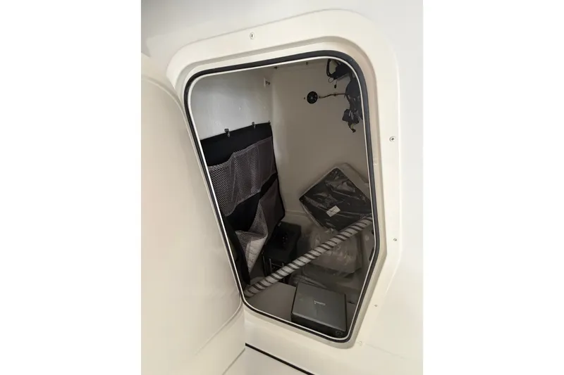 Slide: The Image of Interior view of 2027 Parker 220 Coastal Elite boat storage compartment with organized gear. - 19