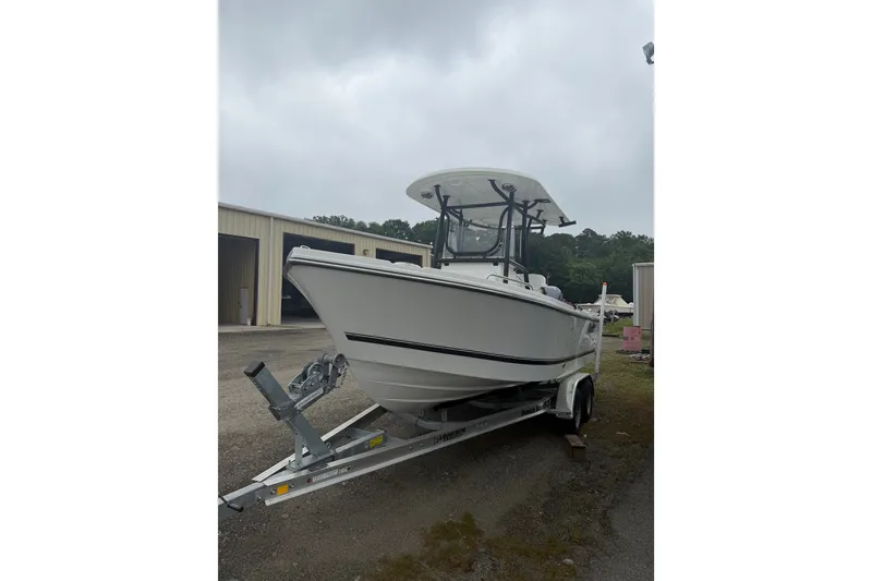 The Image of 2027 Parker 220 Coastal Elite boat on trailer, parked outdoors near storage buildings. - 1