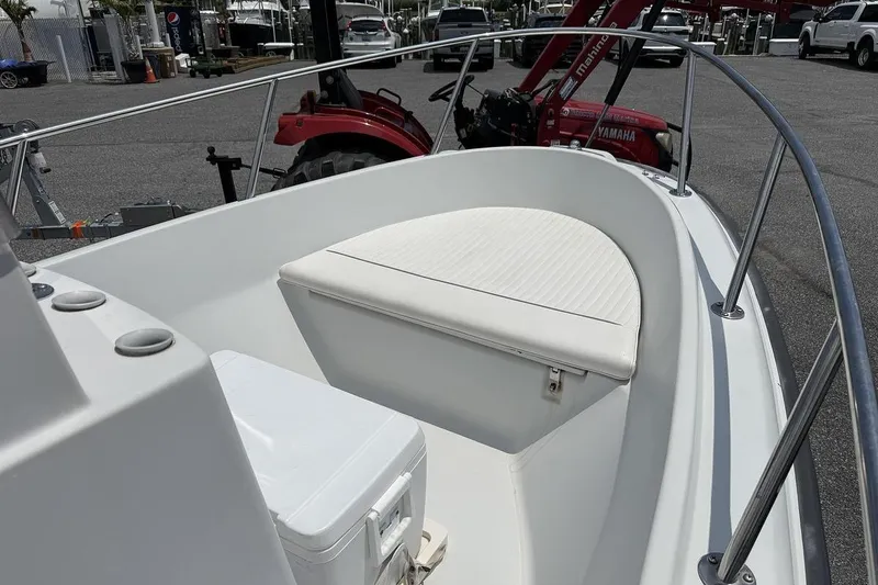 Slide: The Image of 1996 Boston Whaler Outrage 17 boat interior with seating and railing, parked outdoors. - 5