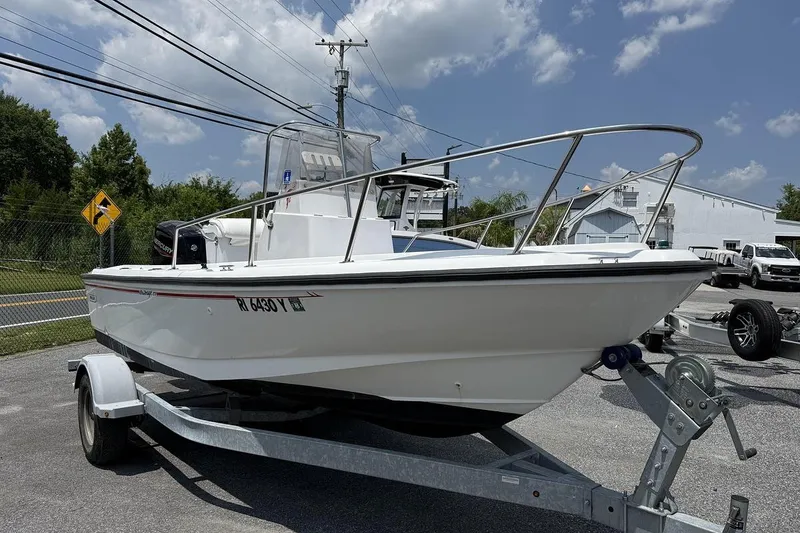 Slide: The Image of 1996 Boston Whaler Outrage 17 boat on trailer under a clear blue sky. - 1